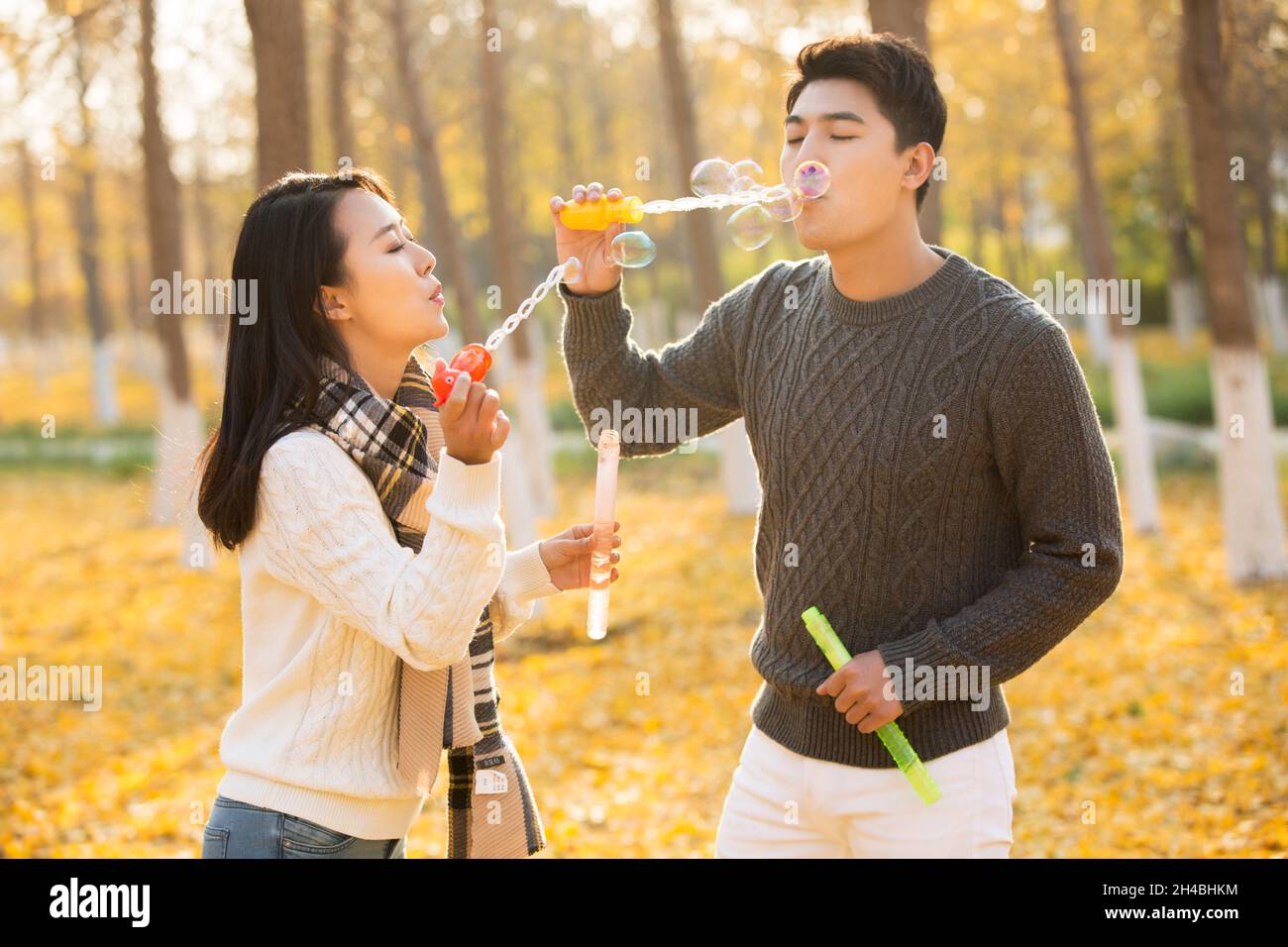 Happy young couple blowing bubbles Stock Photo