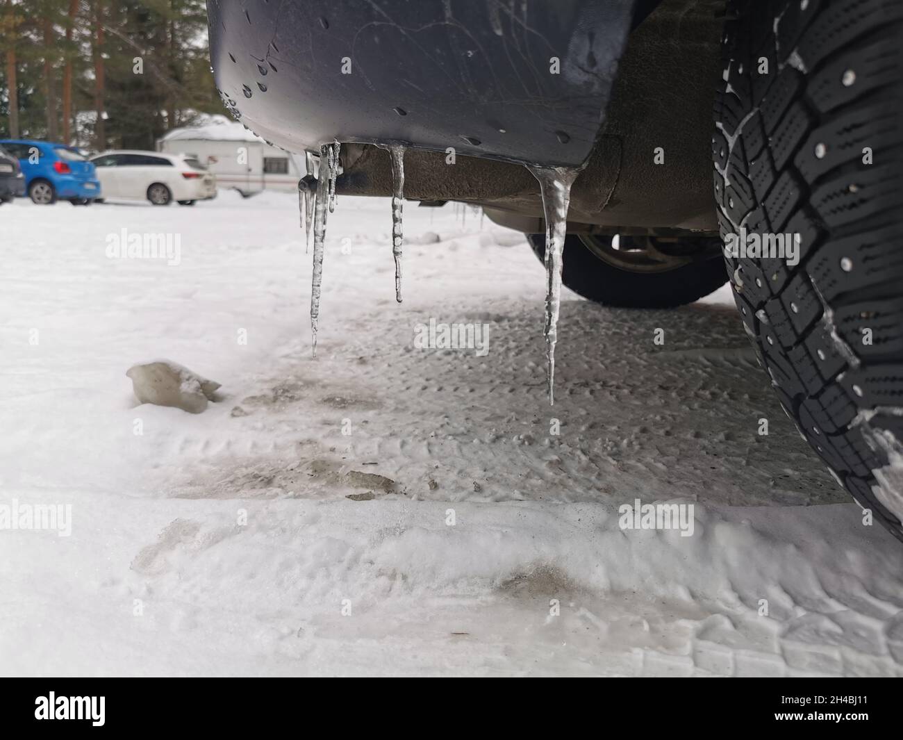 Ice shards coming down from a car rear bumper. Stock Photo