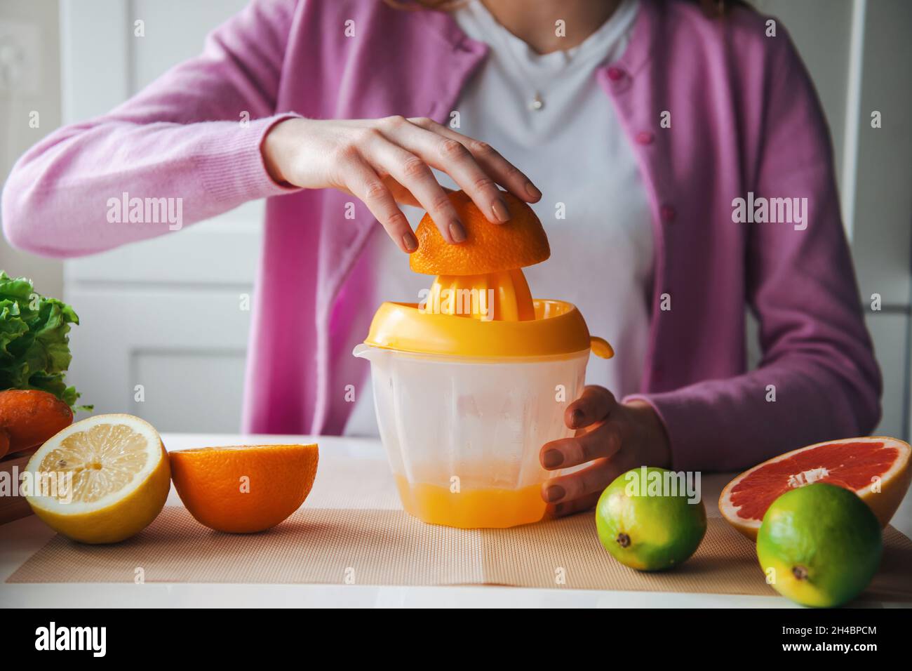 Woman making fresh juice at home. Healthy lifestyle. Morning routine Stock Photo