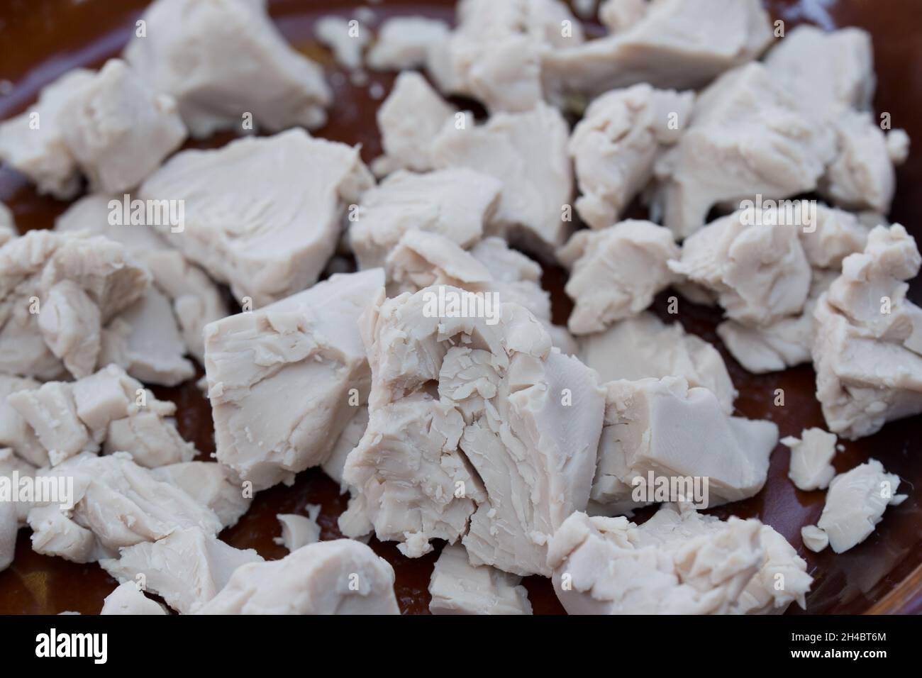 fresh yeast crumbled on plate closeup selective focus Stock Photo