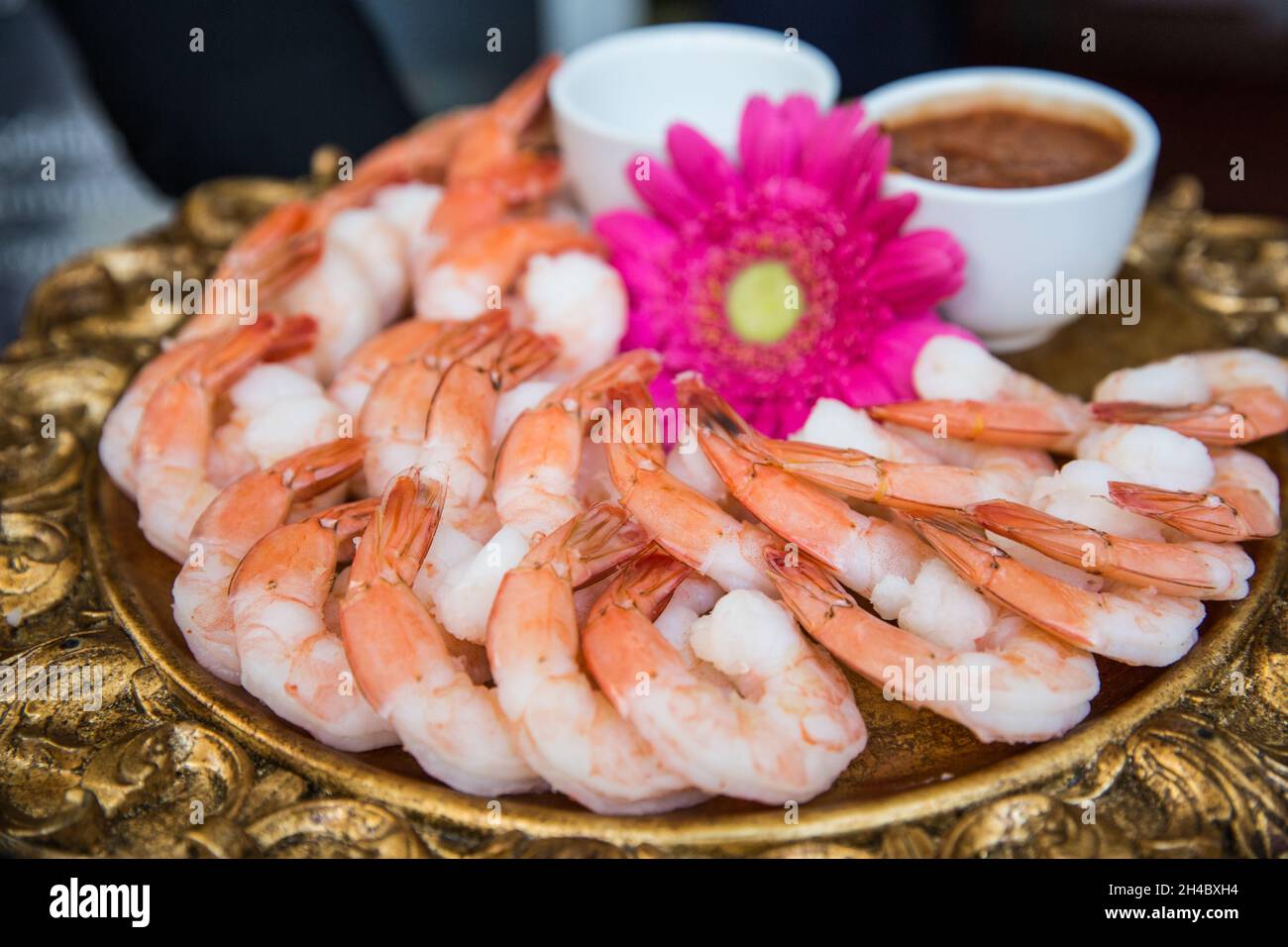 A golden plate with fresh prawns is on display at an event. Stock Photo