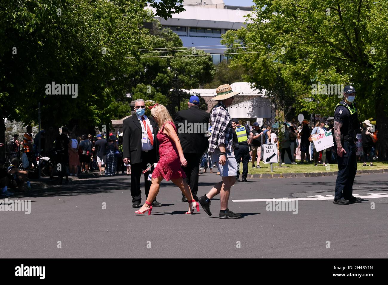 Melbourne, Australia, 2 November, 2021. Race goers pass the protests as 10,000 race goers descended on Flemington Racecourse for the 2021 Melbourne Cup, demonstrators marched to the racetrack to protest vaccine mandates and the proposed laws in state parliament that will allow police to jail anti-lockdown protesters for up to two years. Credit: Michael Currie/Speed Media/Alamy Live News Stock Photo