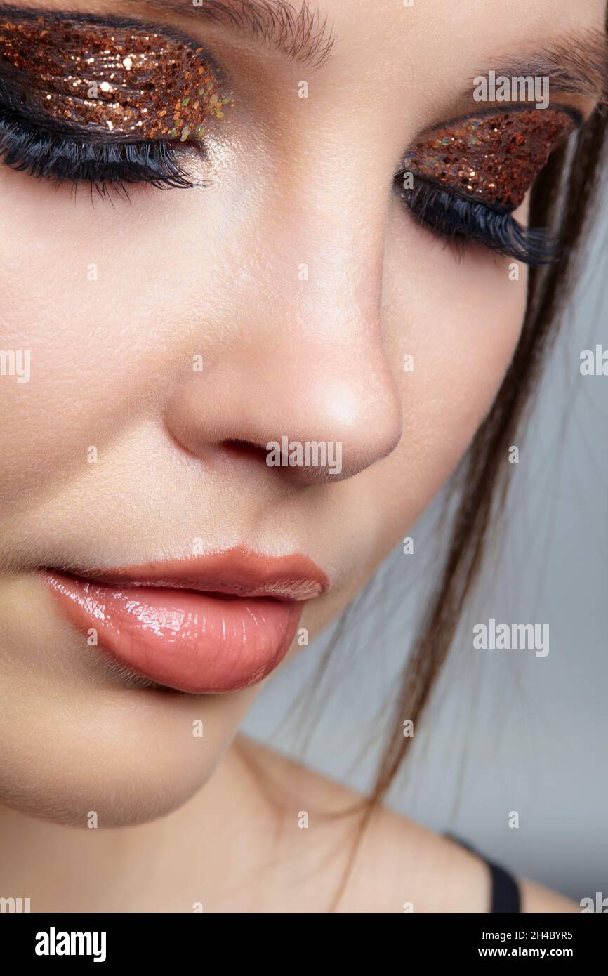 Close-up shot of female face with vogue golden shining eyes makeup. Eyes closed. Stock Photo