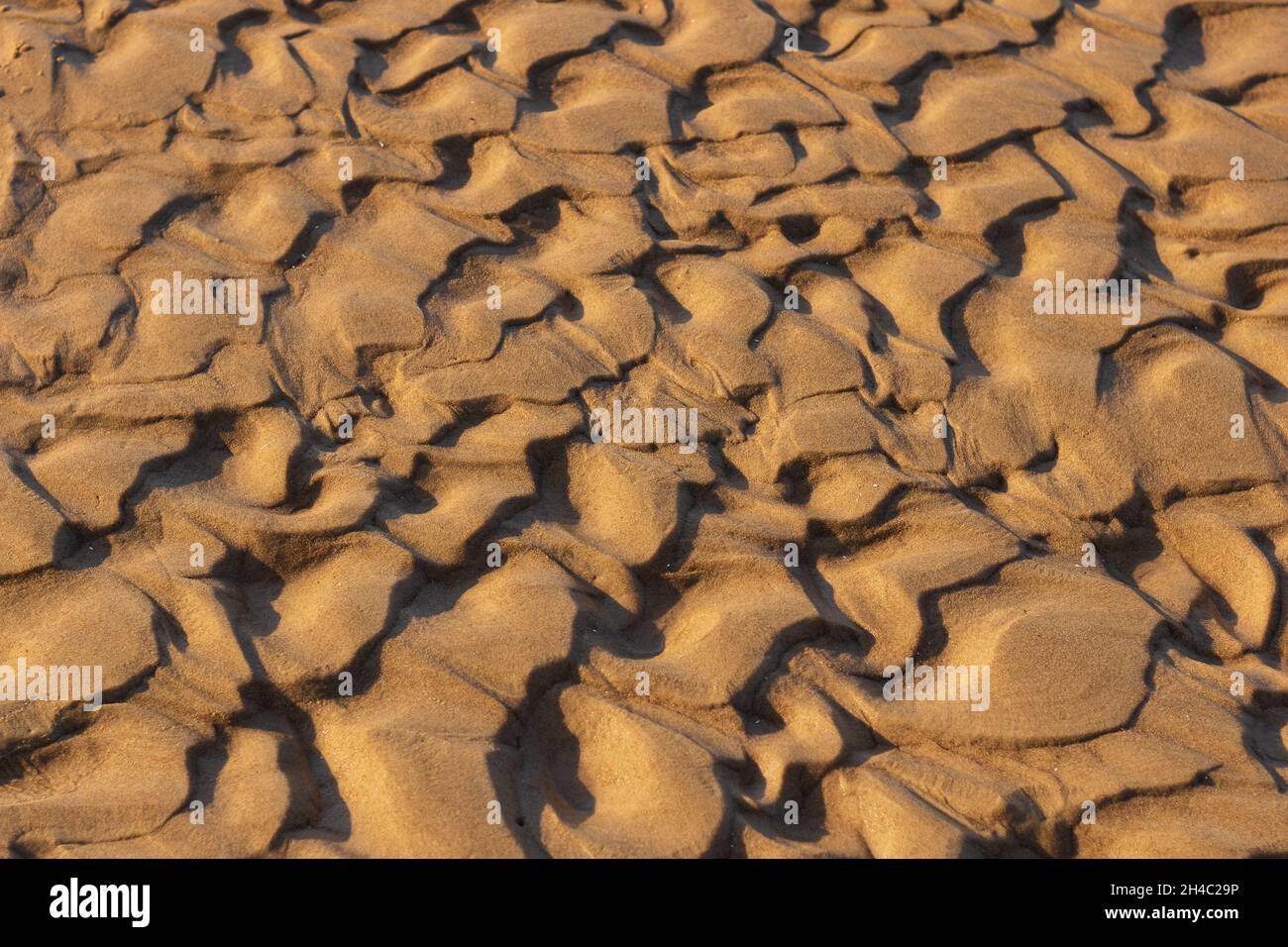 Stylish and natural wallpaper for nature lovers. The sea waves washed away, written, unique drawings and patterns, similar to the desert. The sand is Stock Photo