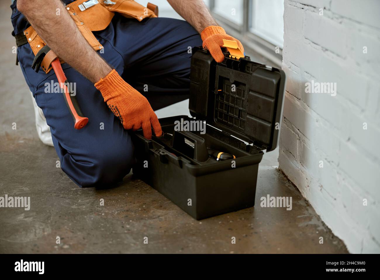 Male electrician in work gloves using tool box Stock Photo