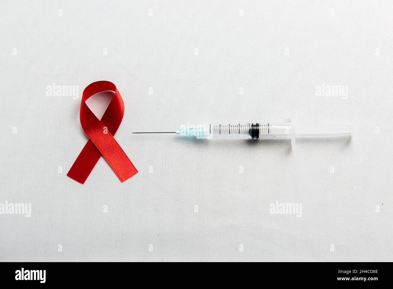 Red ribbon and syringe with white background. Hiv Aids ribbon awareness ...