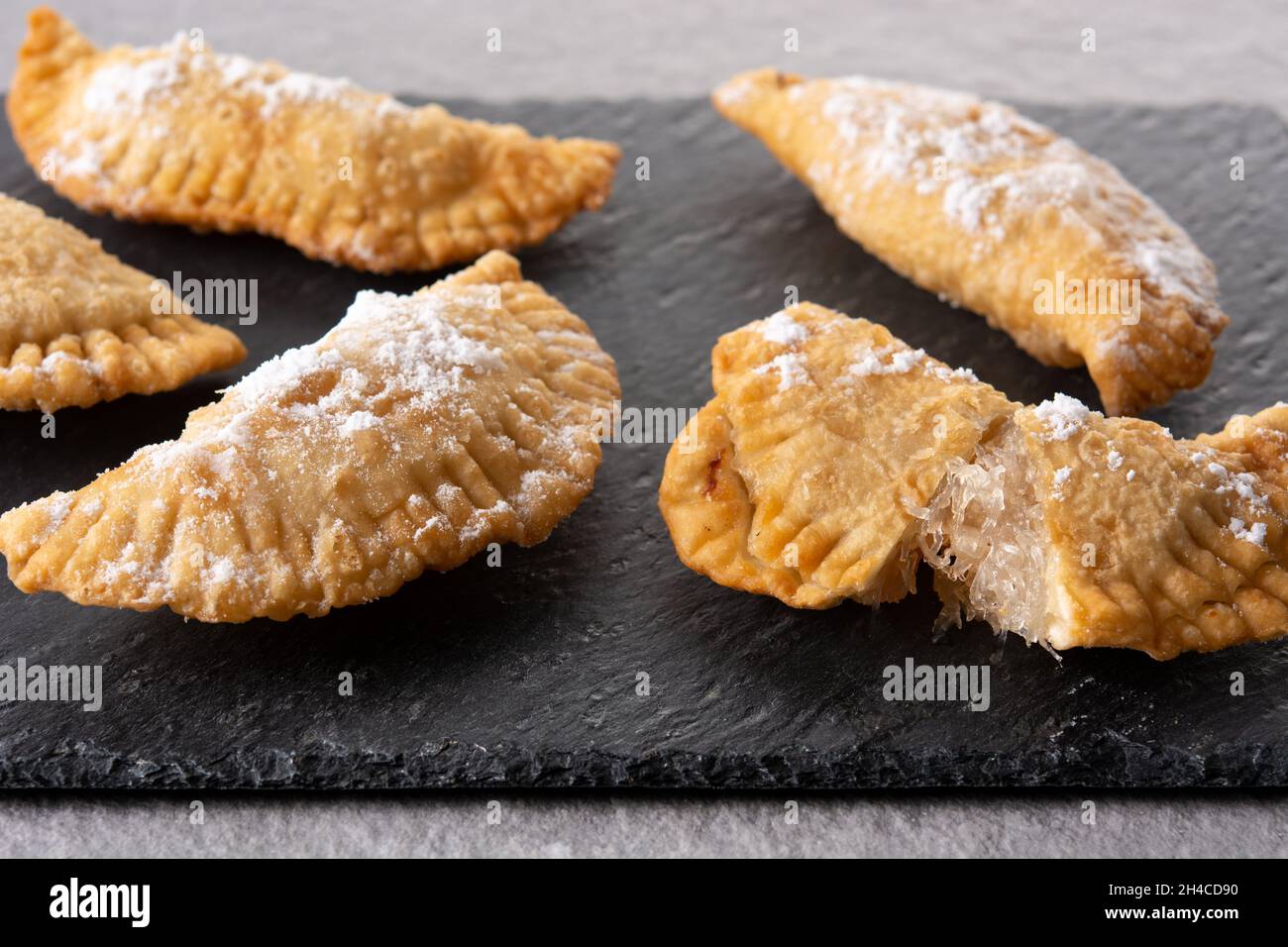 Spanish sweet stuffed pastry filled with angel hair on wooden table ...