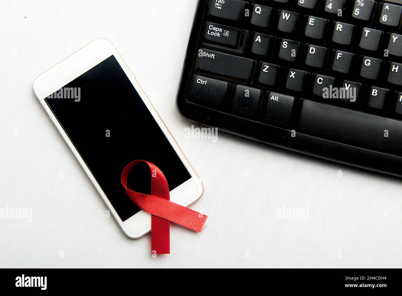 Red ribbon and mobile phone with white background. Hiv Aids ribbon ...