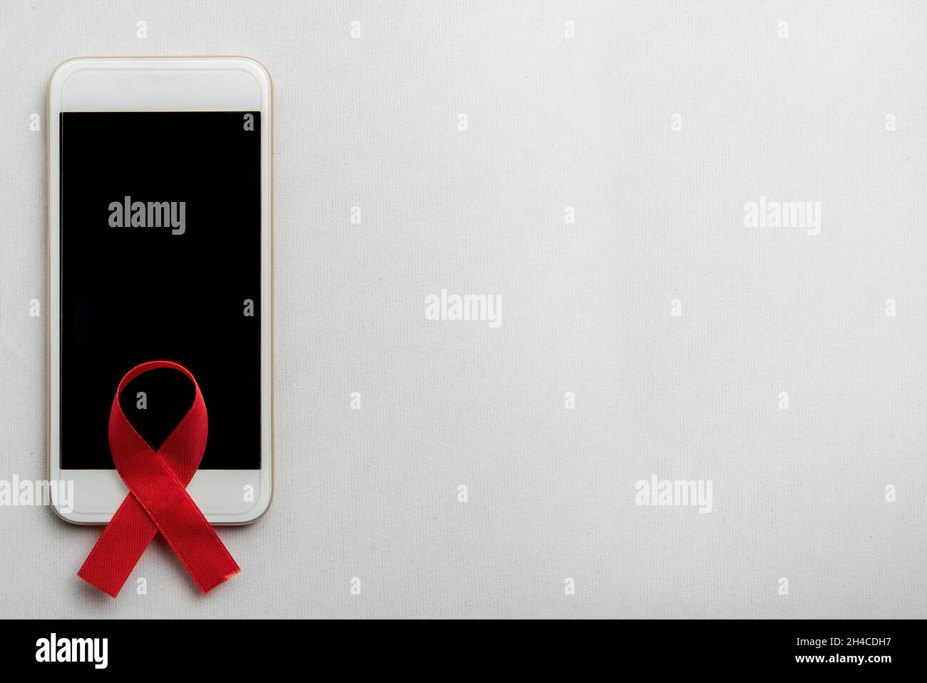 Red ribbon and mobile phone with white background. Hiv Aids ribbon ...