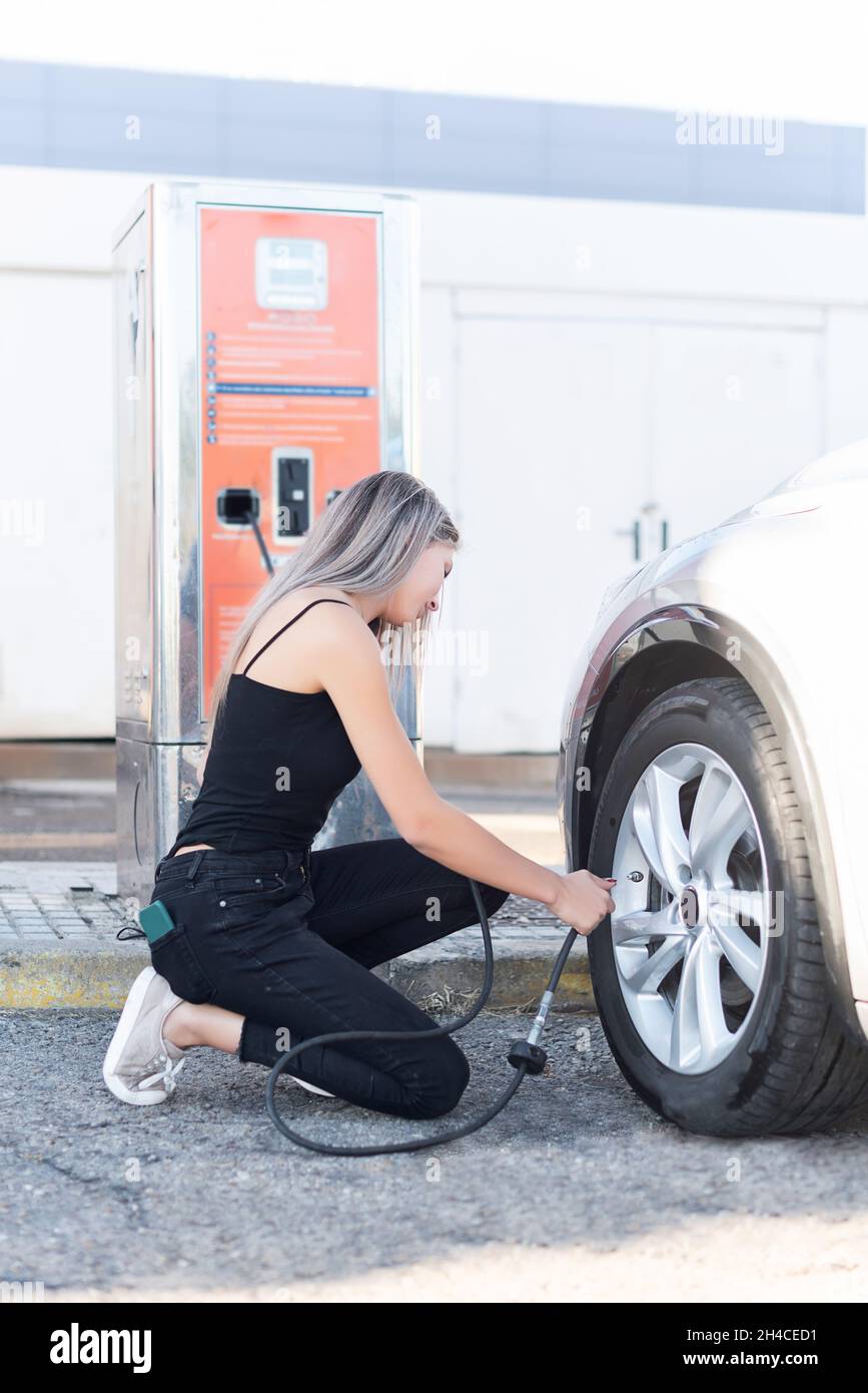 Nahaufnahme einer älteren Frau, weibliche Hände mit automatischer Luftpumpe  zu füllen Autoreifen mit niedrigem Druck Stockfotografie - Alamy