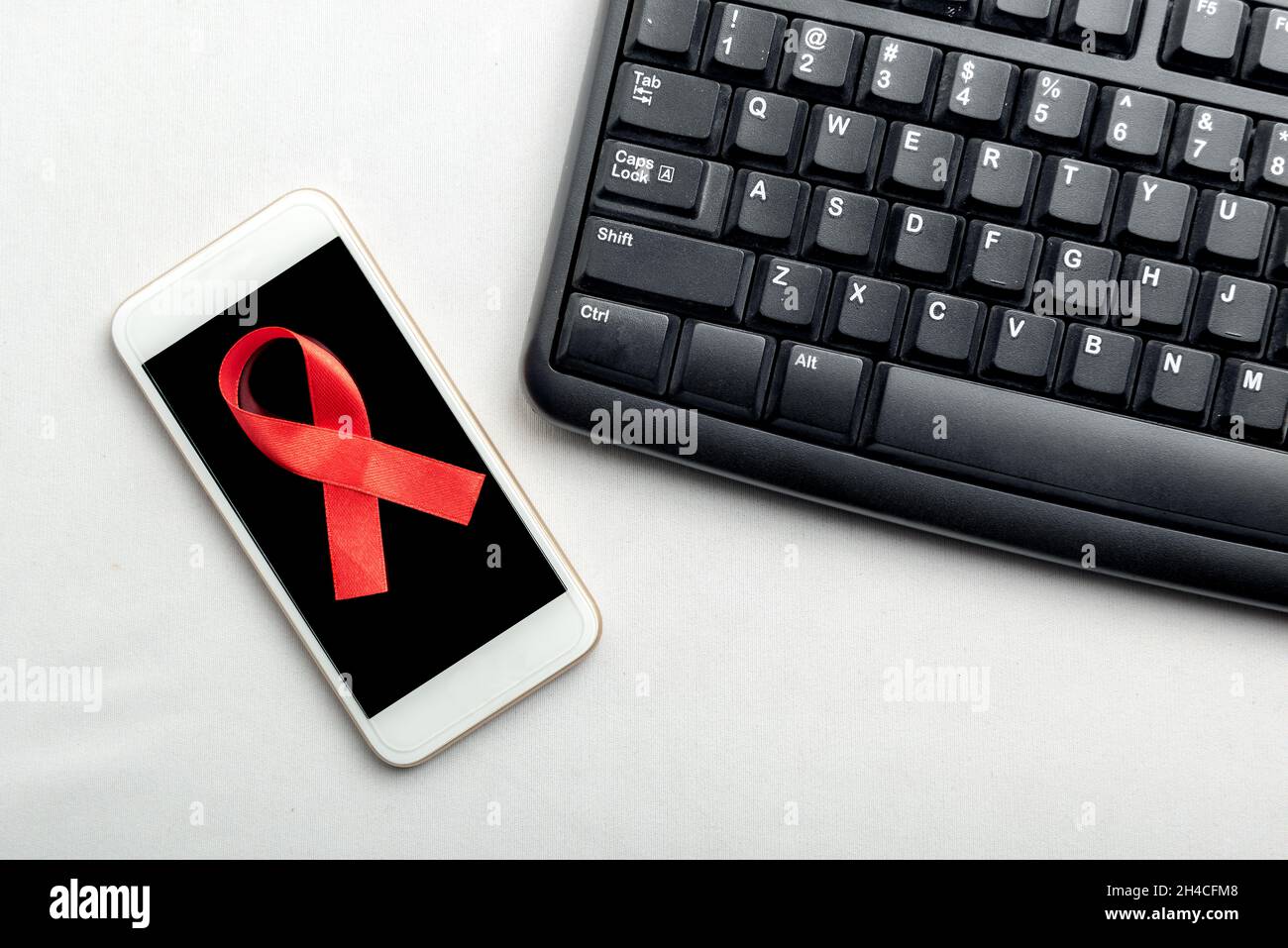 Red ribbon and mobile phone with white background. Hiv Aids ribbon ...