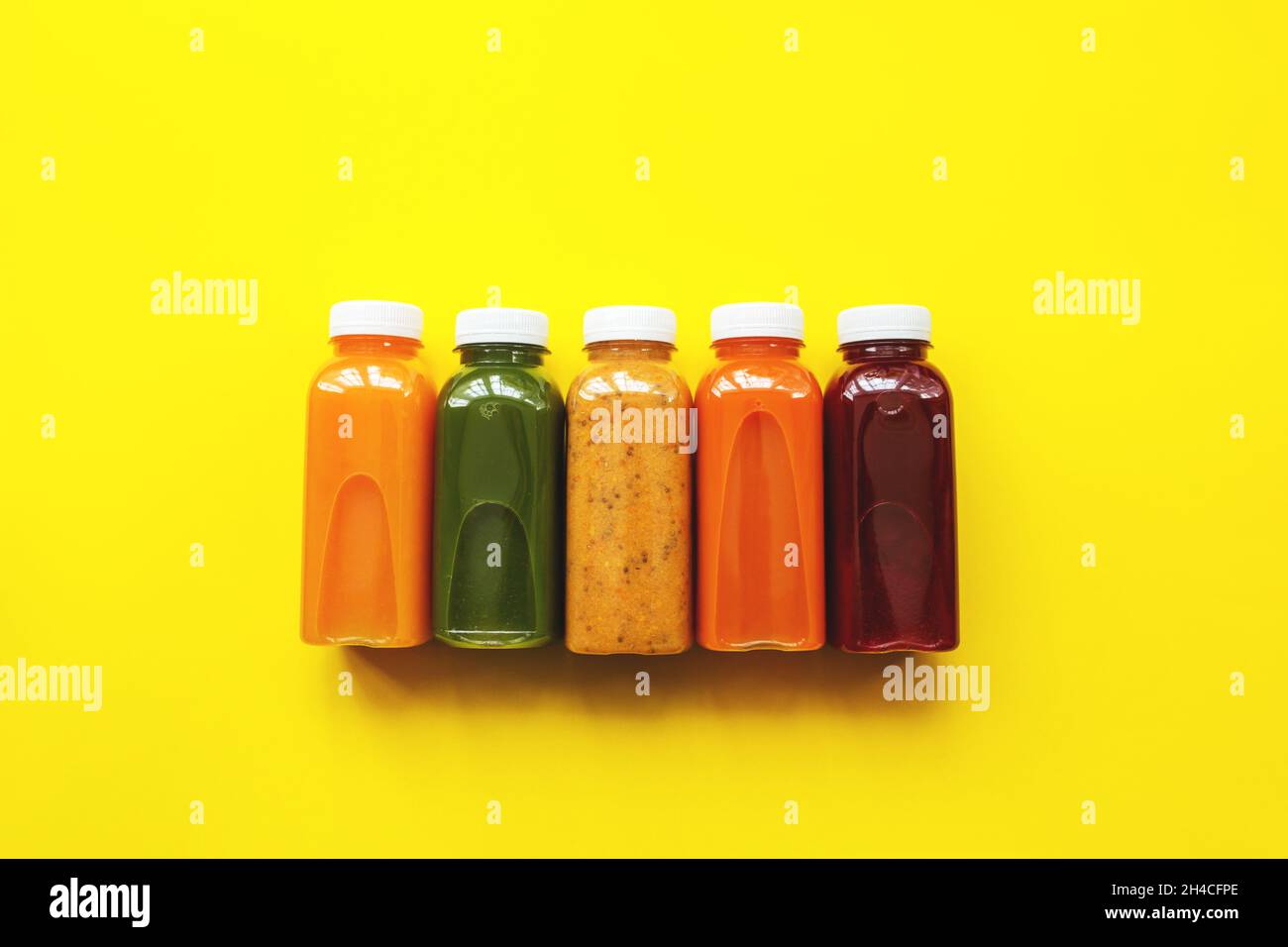 Fresh juices or cocktails of fruits and vegetables in bottles on a yellow background. The concept of a healthy diet or diet. Fresh organic ingredients Stock Photo