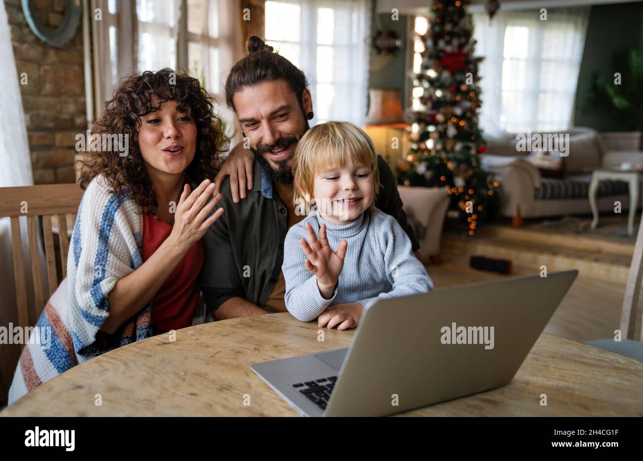 Happy young family making video call with laptop at home Stock Photo