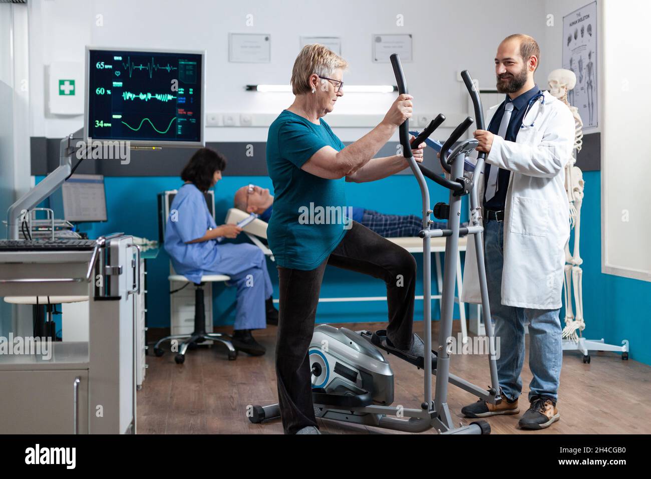 Aged woman using electrical bicycle for physical exercise to recover