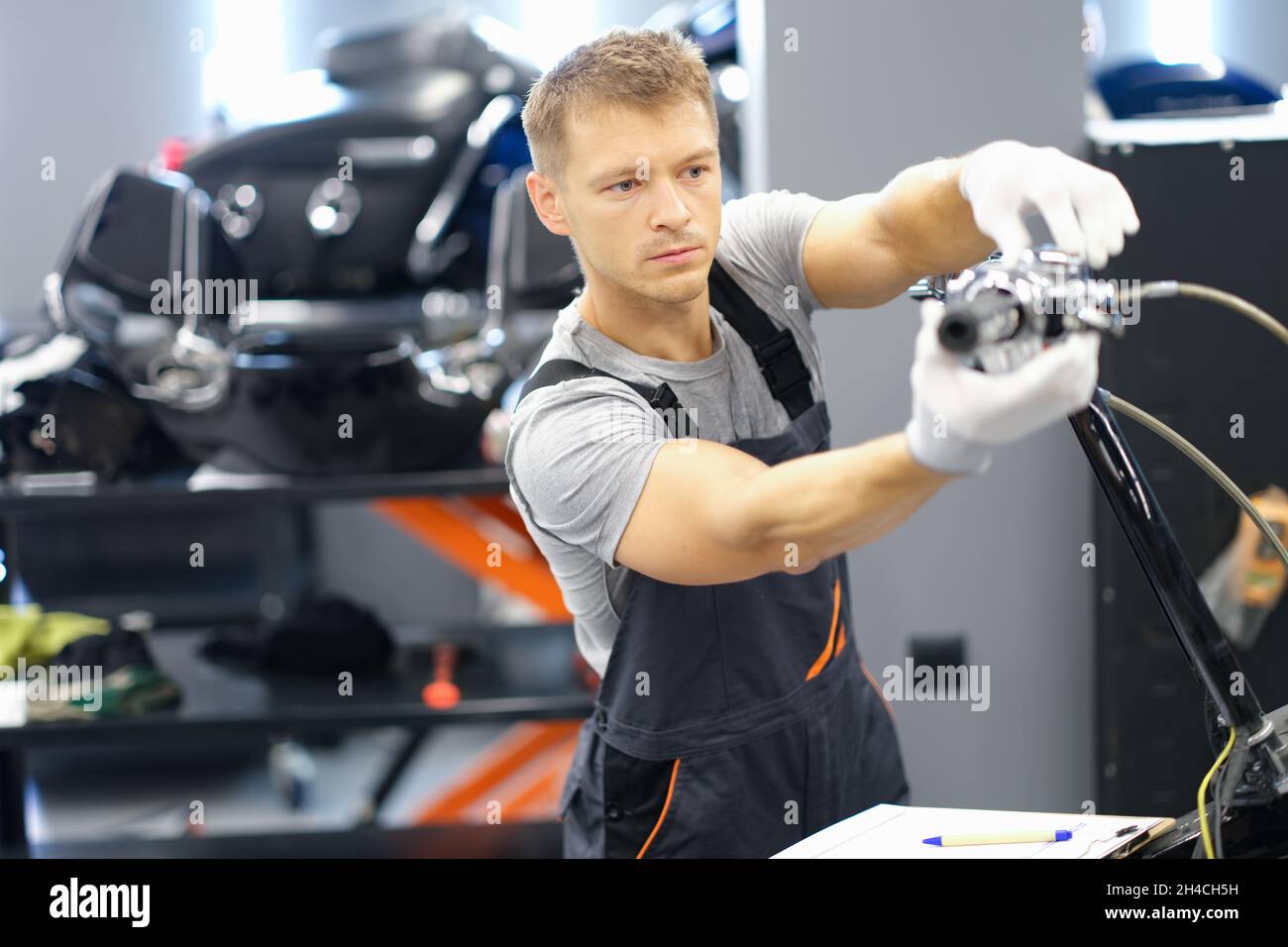 A male racer in a garage changes parts of a motorcycle Stock Photo - Alamy