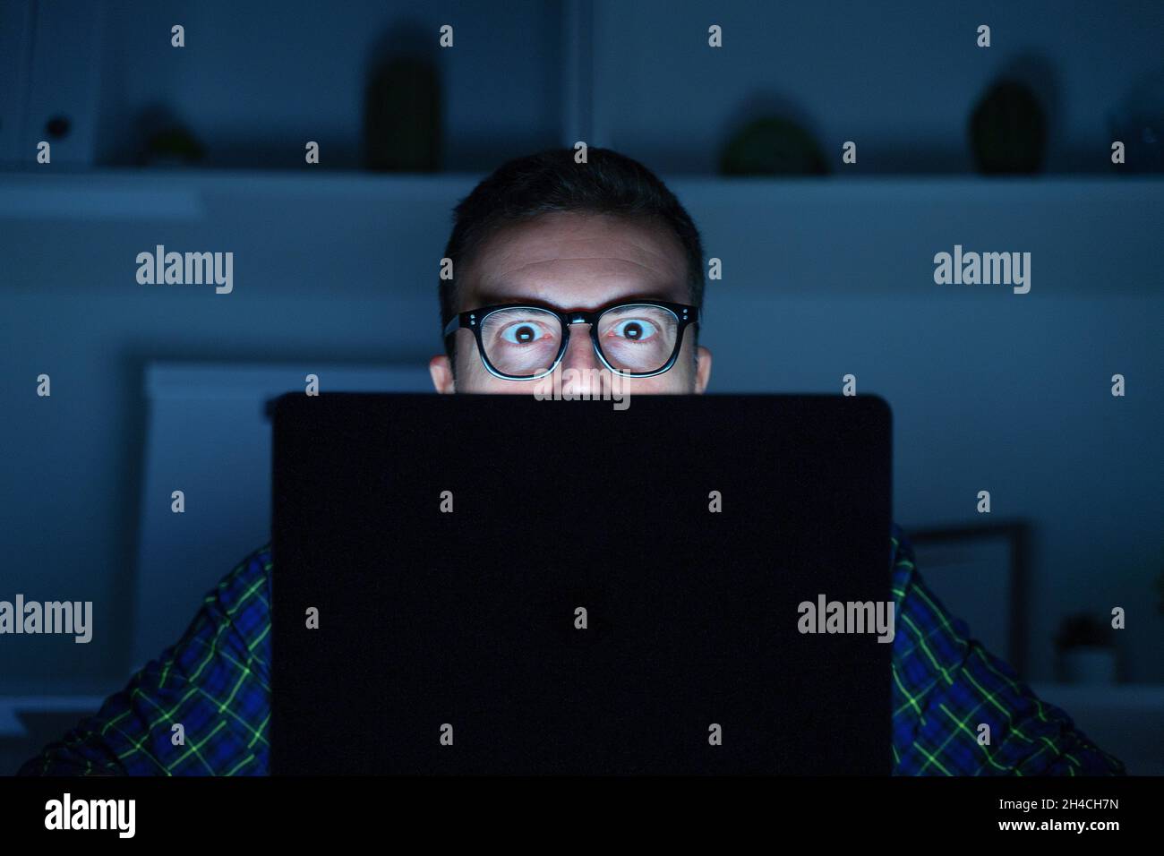 One geek guy using laptop at night Stock Photo