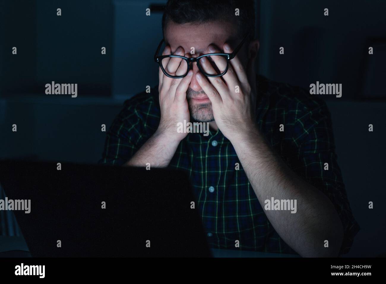 Man with eye strain computer problem at night Stock Photo