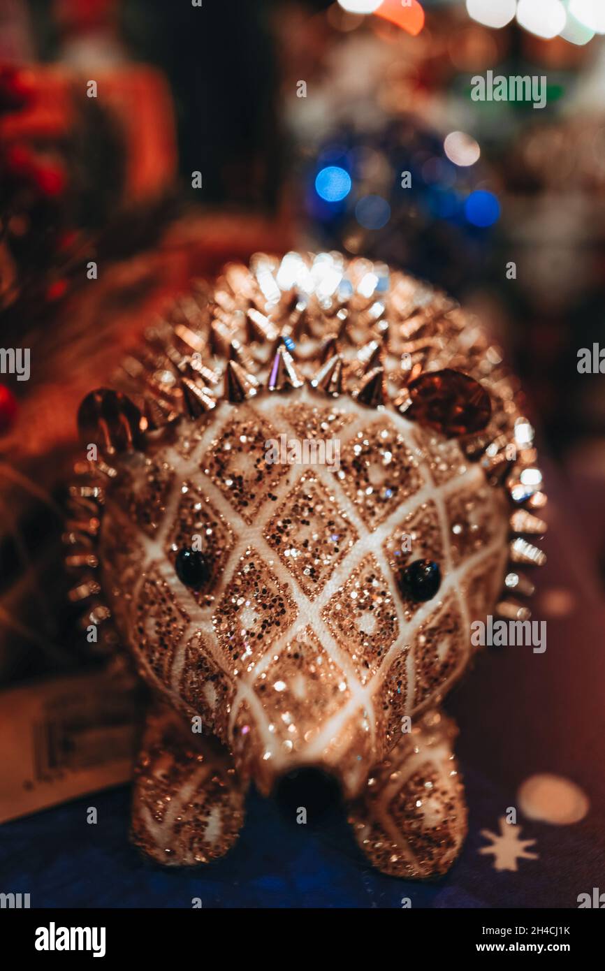 Christmas toy golden shiny hedgehog. Christmas details in a festive interior and decorations. New Year atmosphere Stock Photo