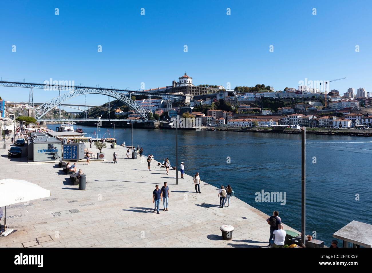 Fußgängerpromenade entlang des Douro in der Altstadt von Porto. Im Hintergrund ist die Brücke Pond Luis I zu sehen. Menschen flanieren, sind nicht zu . Stock Photo