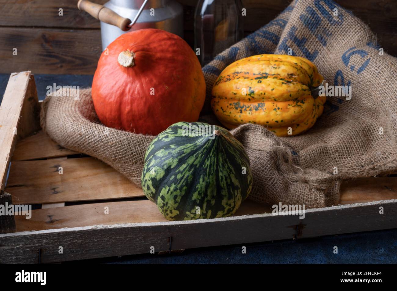 Pumpkins lying on a straw sack in a wooden box Stock Photo - Alamy