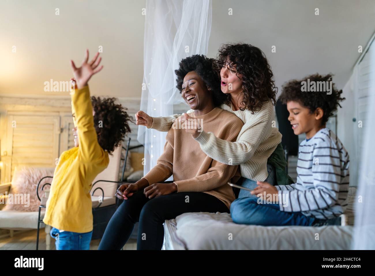 Happy lesbian multiethnic couple in love with childen at home. Family lgbt child happiness concept Stock Photo