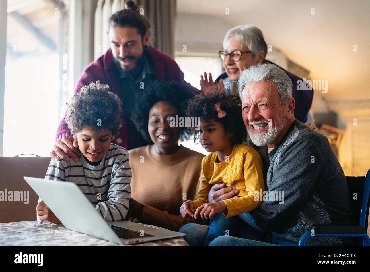 Portrait of a happy multigeneration family using electronic devices at home together Stock Photo