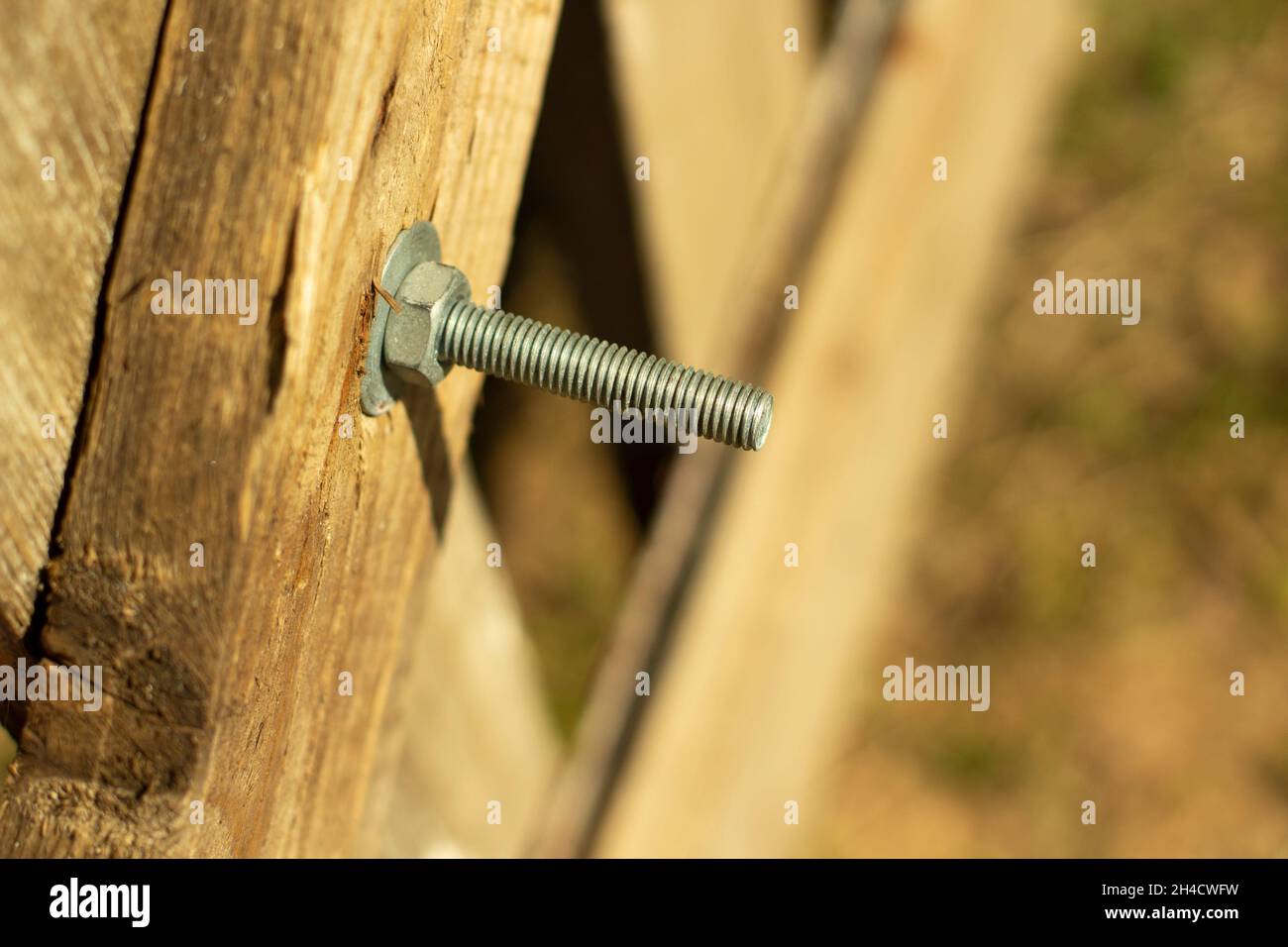 Bolt screwed into the board. Thread on the bolt. The nut is twisted on