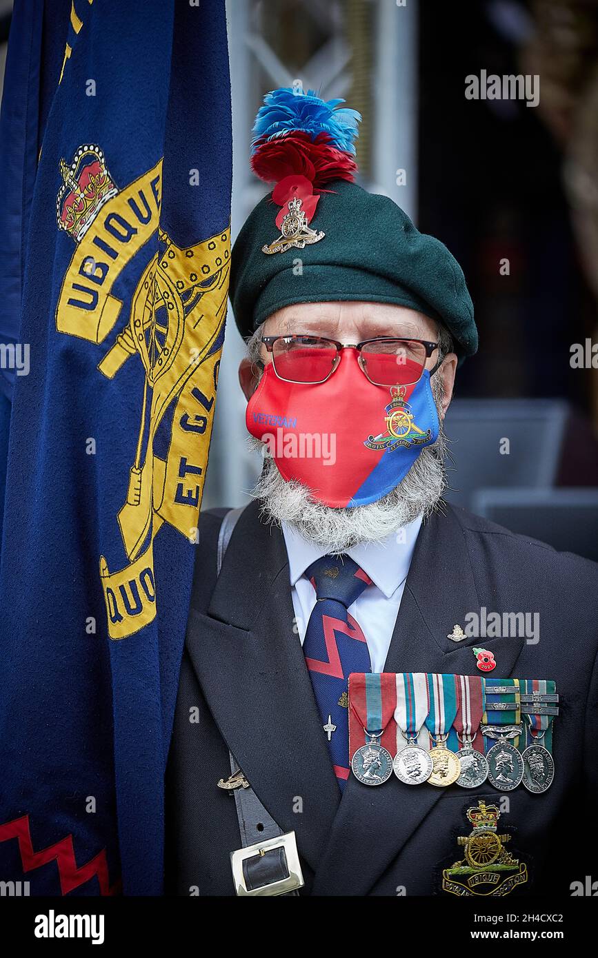 Veteran standard bearer from the Royal Regiment of Artillery, medals and covid face mask Stock Photo
