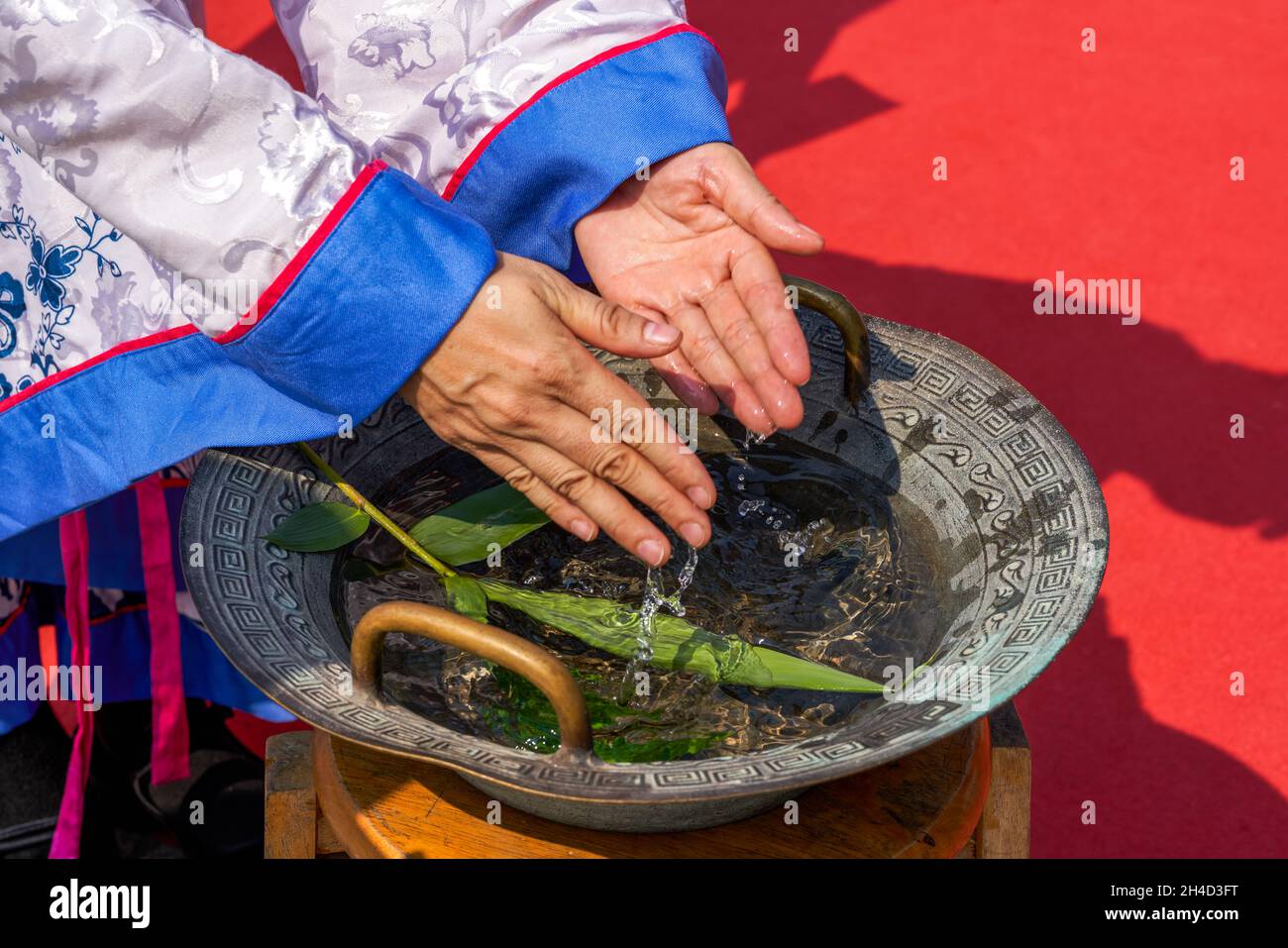 People wash their hands in the bronze basin at the ceremony to worship Confucius Stock Photo