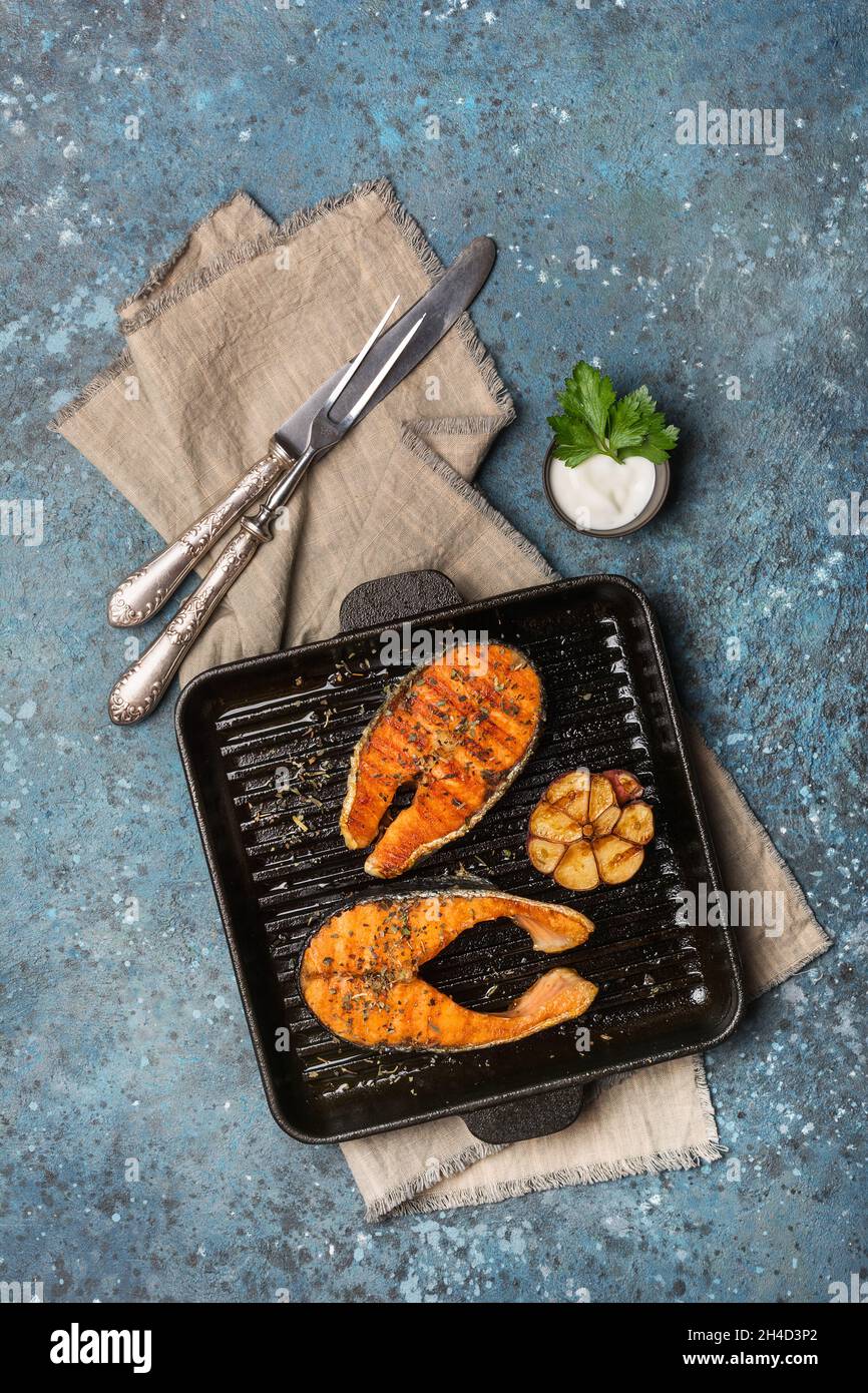 Grill pan with delicious salmon steaks on stove in kitchen Stock Photo -  Alamy