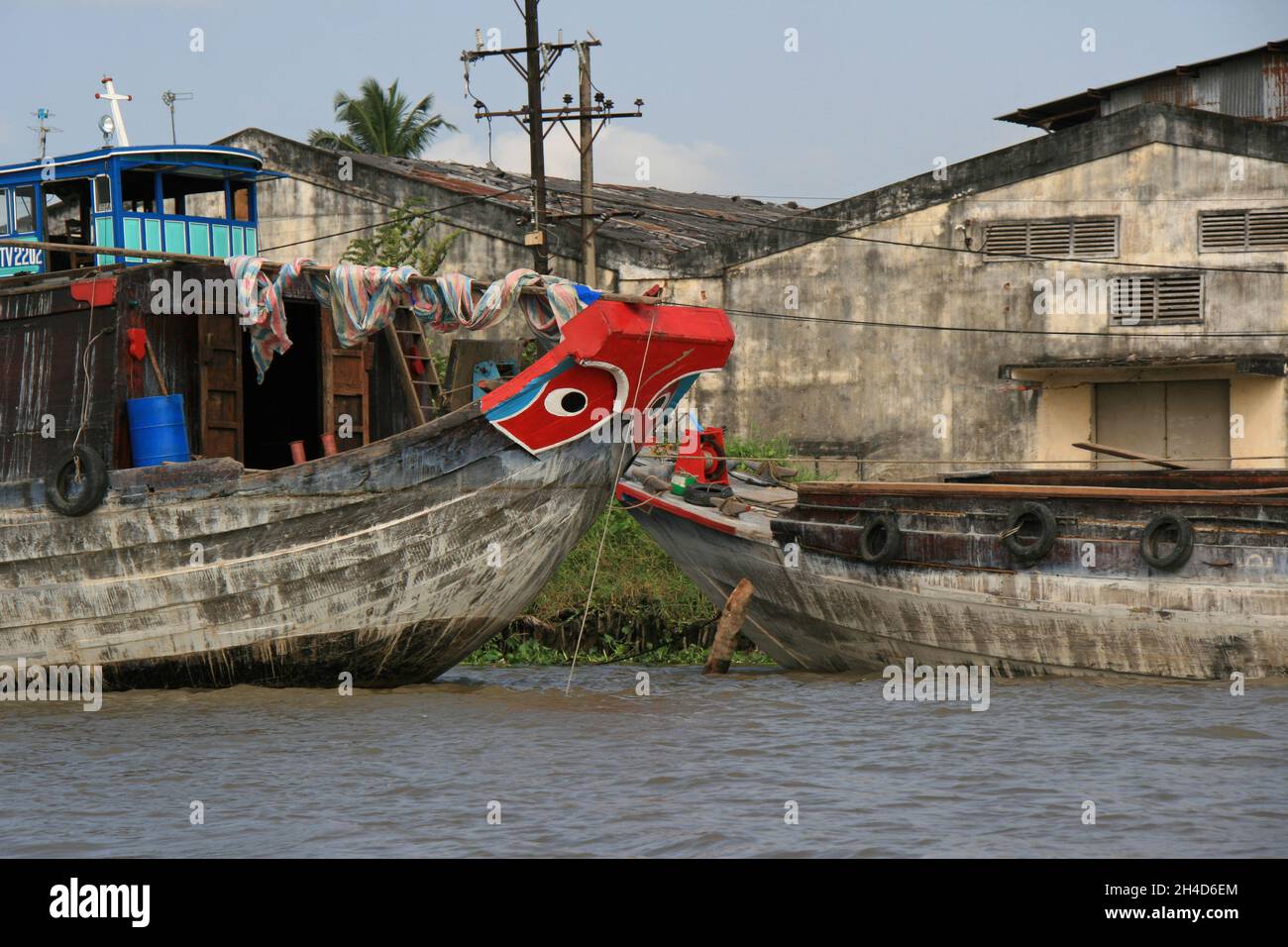 boats and warehouses along a river at the delta of mekong in vietnam ...