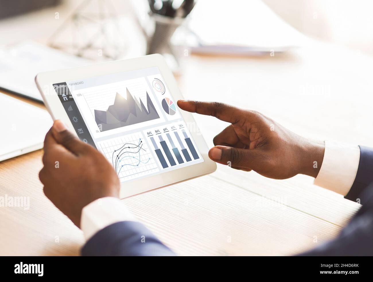 Cropped young black businessman use tablet with financial app for passive income at workplace in office Stock Photo