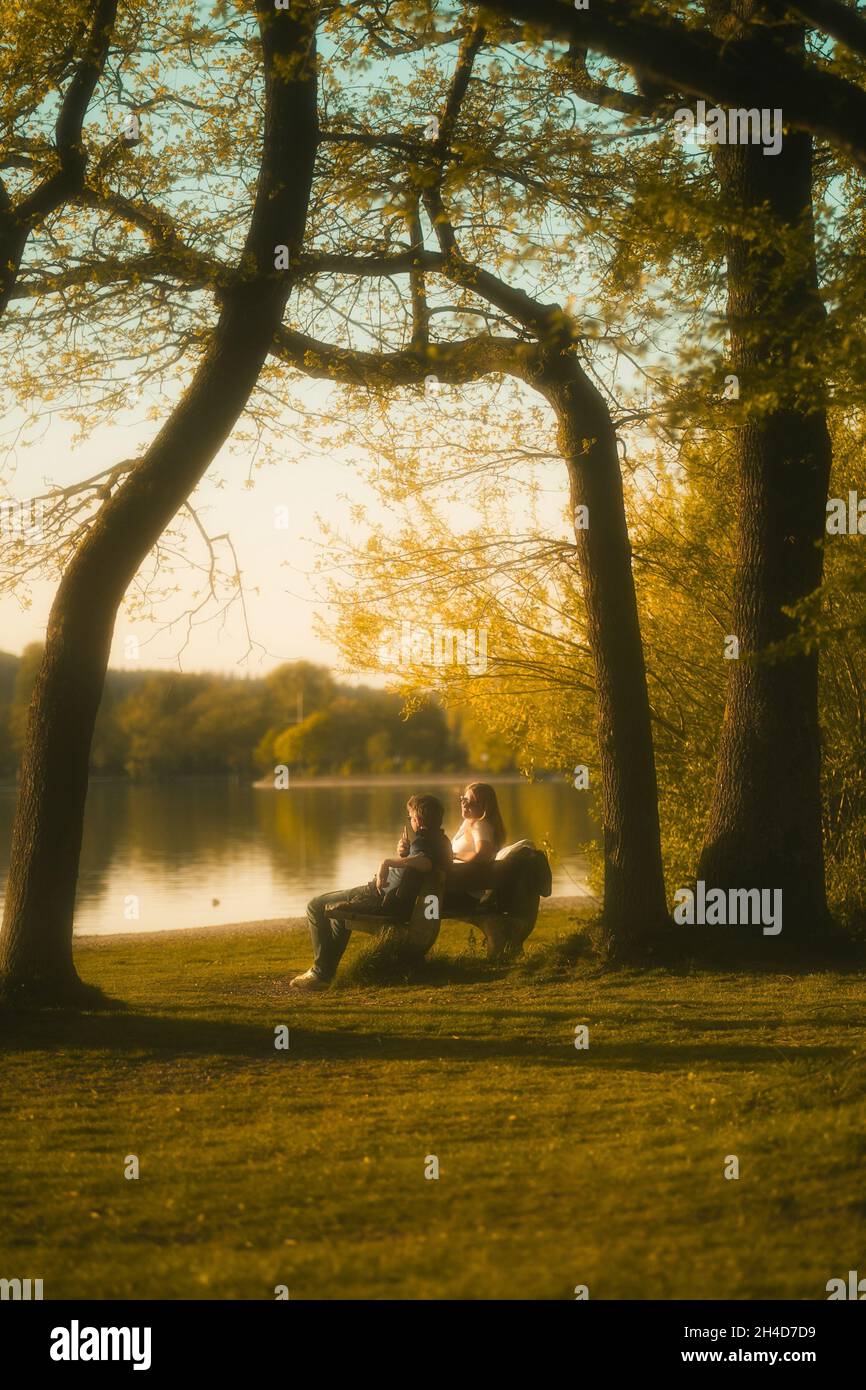 Starnberg, Deutschland . 27th Apr, 2021. Pärchen sitzt am Seeufer des Starnberger Sees im Bereich von Kempfenhausen. Die Sonne ist kurz davor unter zu gehen. * Couple sitting on the shore of Lake Starnberg in the area of Kempfenhausen. The sun is about to set. (Photo by Alexander Pohl/Sipa USA) Credit: Sipa USA/Alamy Live News Stock Photo