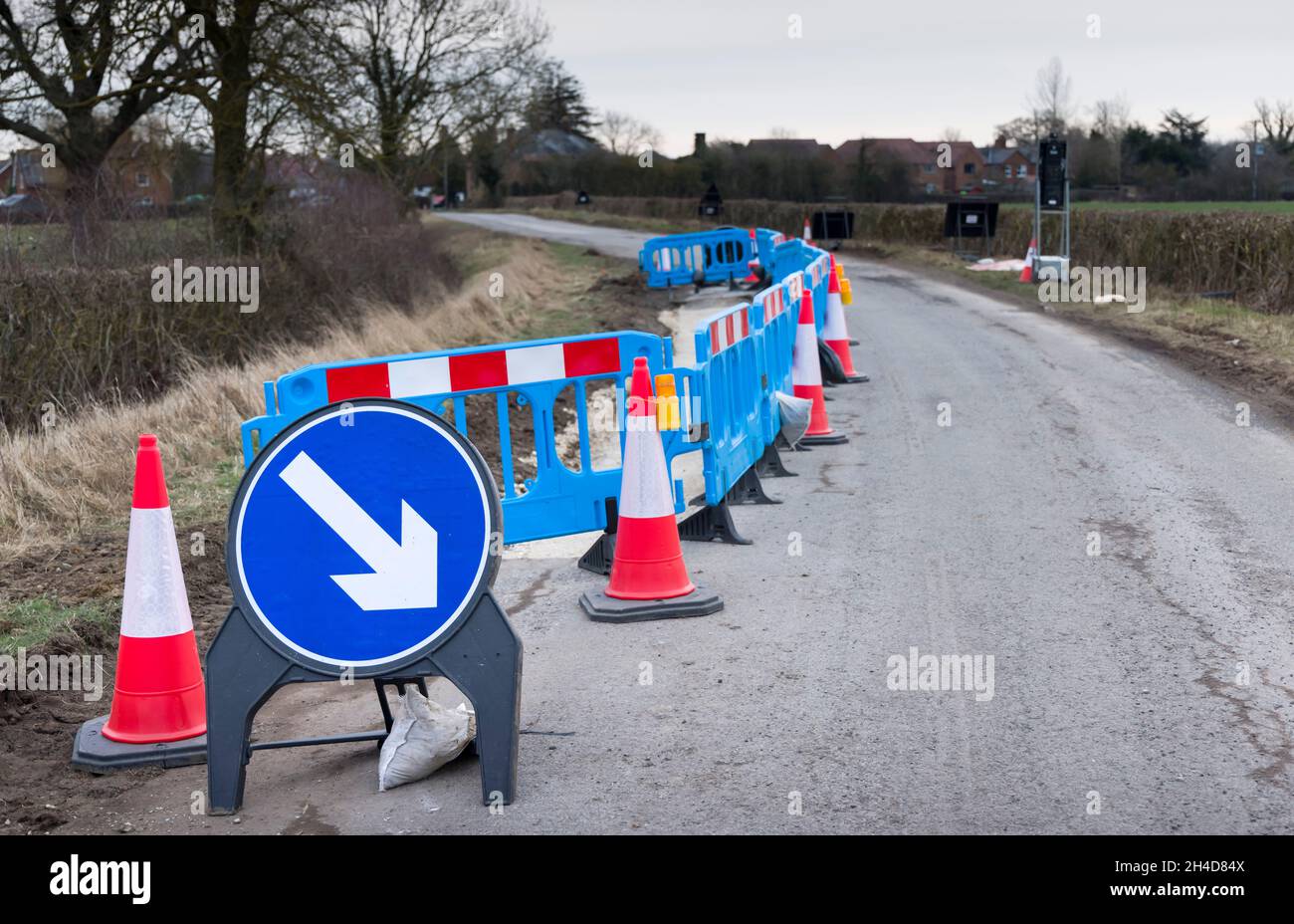 Roadworks with traffic cones and warning sign on a rural country road in Buckinghamshire, UK Stock Photo