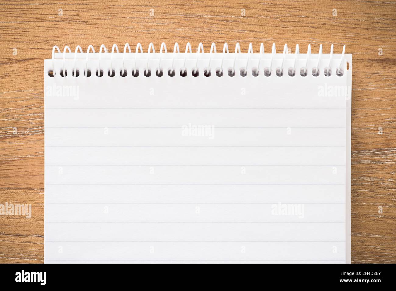 Spiral notebook secretary note pad on a wooden desk. Flat lay template or background Stock Photo