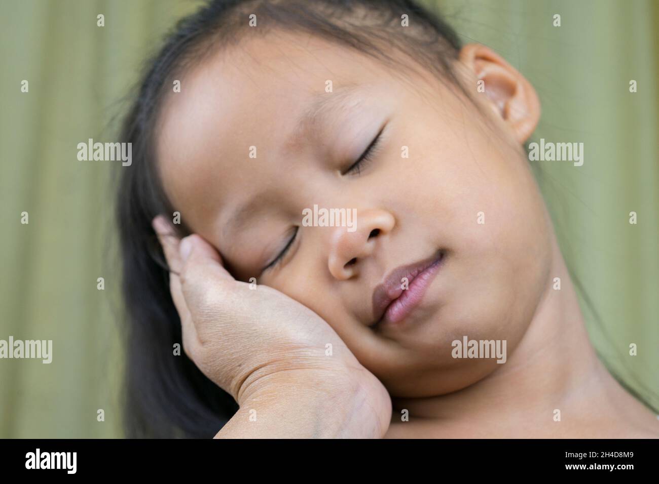 Asian mother and child girl playing pinch cheeks, touch nose funny face. Stock Photo
