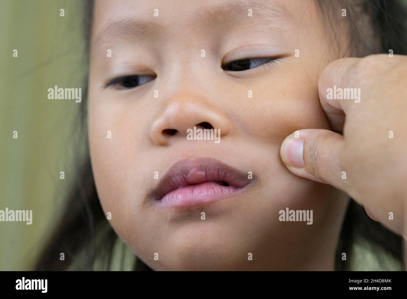 Asian mother and child girl playing pinch cheeks, touch nose funny face. Stock Photo
