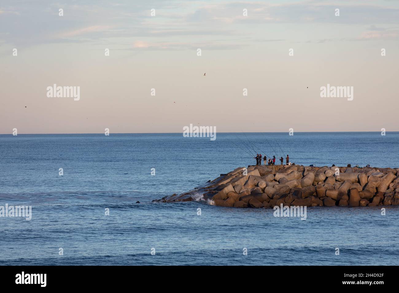 Fischer, nicht erkennbar, Angeln am Steinpier von Espinho am Morgen Stock Photo