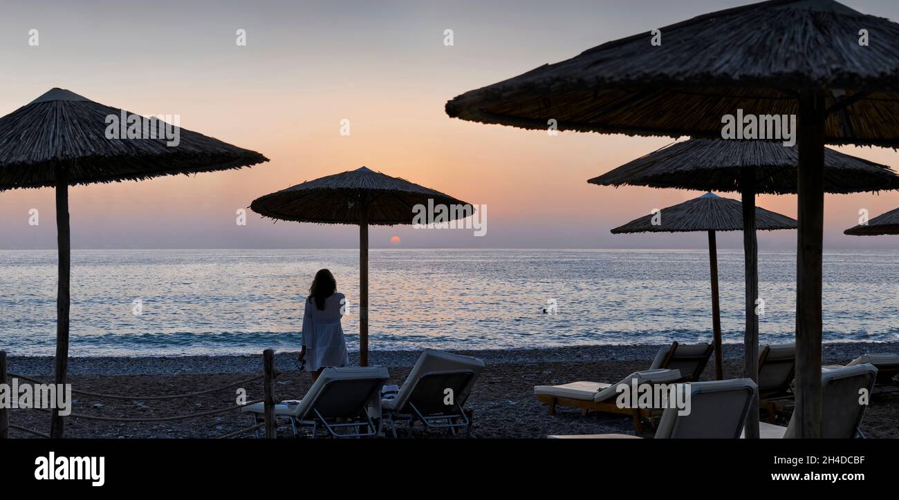 Panoramic photograph of umbrellas and sunloungers on beach in Coral Bay,Cyprus at sunset Stock Photo
