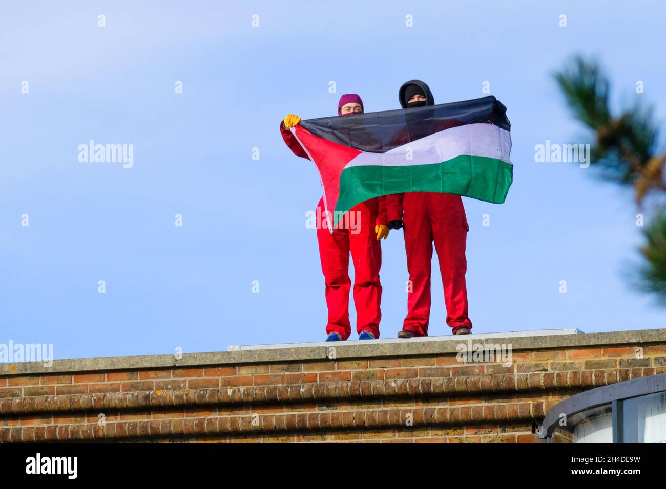 Aztec West Business Park, Bristol, UK. 2nd Nov, 2021. Two protestors have climbed on the roof of the Bristol office of the defence contractor Elbit Systems UK. The protestors are waving a Palestinian flag and shouting “Close Elbit down”. Elbit is an international company which originated in Israel. Credit: JMF News/Alamy Live News Stock Photo