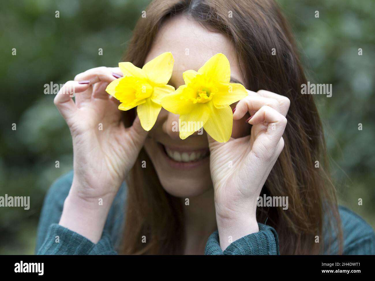 A girl plays with a couple of daffodils on St David's Day at St John's Churchyard Gardens, Cardiff, Wales. Picture dated: Wednesday March 1, 2017. Photo credit should read: Isabel Infantes / EMPICS Entertainment. Stock Photo