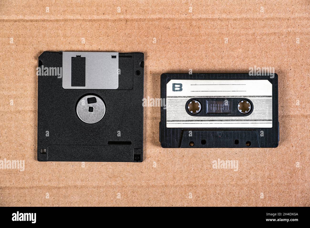 Floppy Disk Drive and Old Audio Cassette on the Cardboard Background