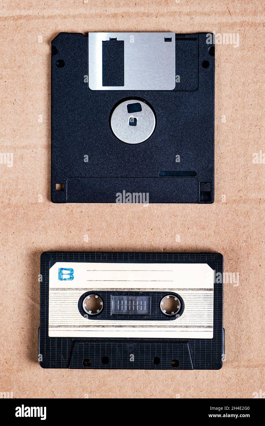 Floppy Disk Drive and Old Audio Cassette on the Cardboard Background closeup Stock Photo