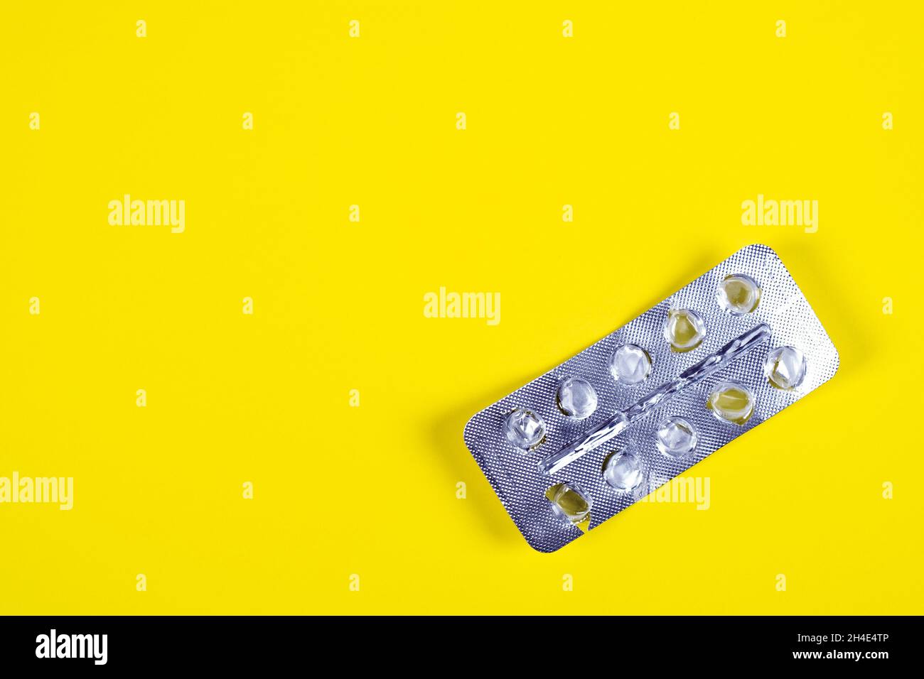Empty Pack of the Pills on the Yellow Paper Background closeup Stock Photo