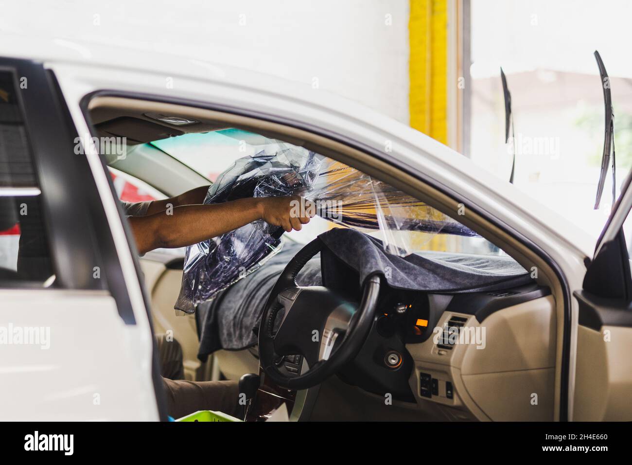 Man specialist removing the old tint film from car window Stock Photo