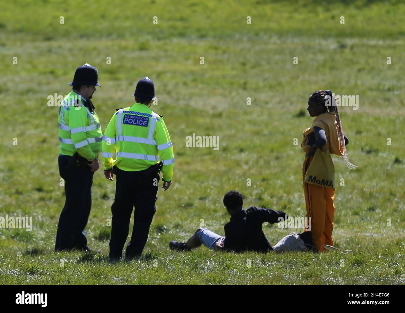 Police move on sunbathers at Primrose Hill, north London, as the UK continues in lockdown to help curb the spread of the coronavirus Stock Photo