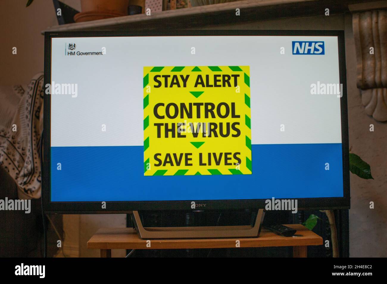 A message reading â€œStay alert. Control the virus. Save livesâ€ is screened on a TV in a home in north London during the Prime Minister Boris Johnson message to the nation about coronavirus (COVID-19) from 10 Downing Street, London. Picture date: Sunday May 10, 2020  Stock Photo