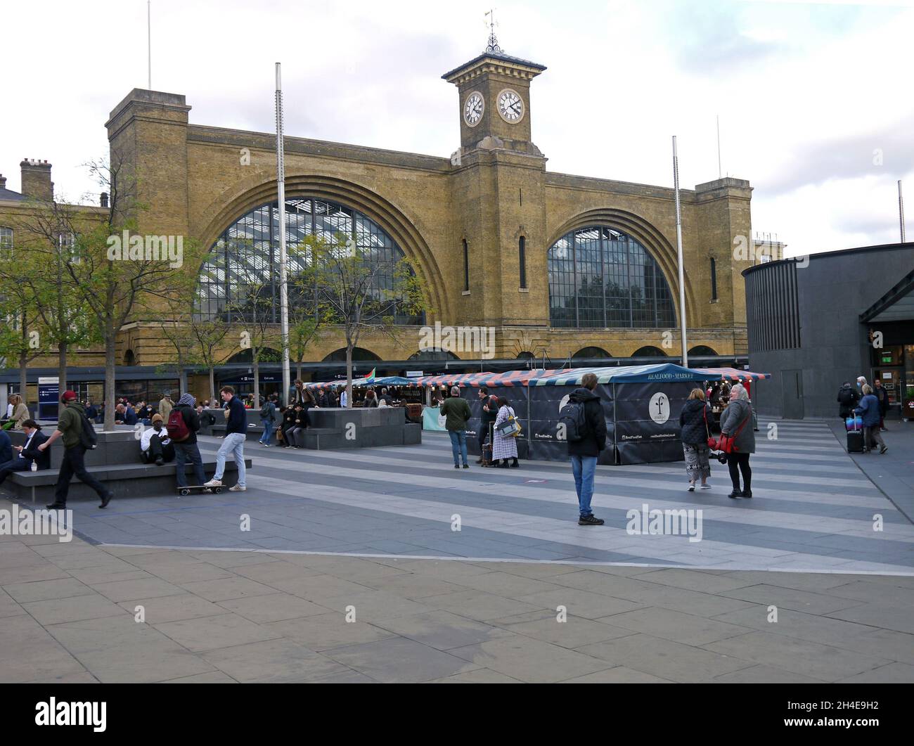 KINGS CROSS. LONDON. ENGLAND. 10-28-21. Kings Cross railway station frontage with a artisan food market on the forecourt. Stock Photo