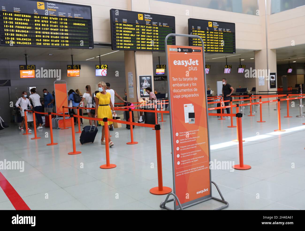 Passengers wearing face covering queue to check in their luggages at the Easyjet desk in Ibiza international airport, Spain, where the tourism industry has been hit hard by the latest 14-day quarantine requirement by the British government for all tourists that travel from Spain because of its high levels of COVID-19 cases. Picture date: Saturday August 1, 2020. Stock Photo