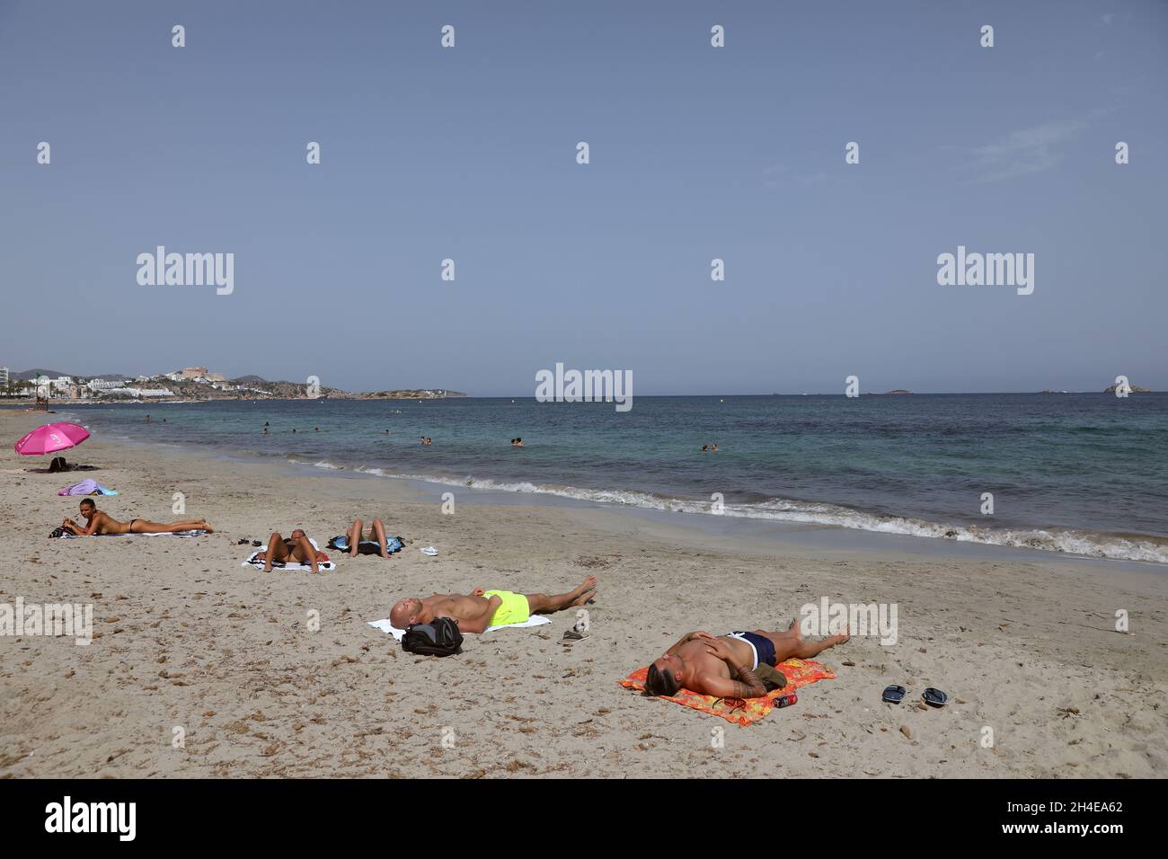 Tourists sunbathe at Playa d'en Bossa in Ibiza, Spain, where the tourism industry has been hit hard by the latest 14-day quarantine requirement by the British government for all tourists that travel from Spain because of its high levels of COVID-19 cases. Picture date: Saturday August 1, 2020. Stock Photo